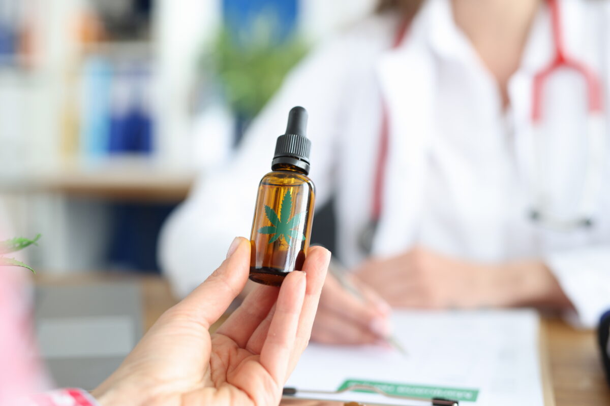 Patient at doctor appointment holds bottle of marijuana oil